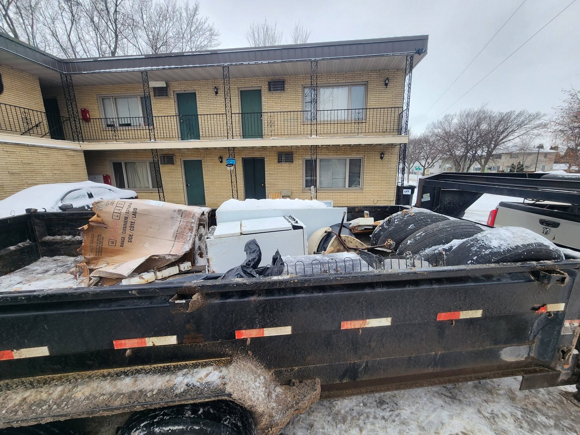 Appliances and junk loaded in the dump trailer at an apartment cleanout