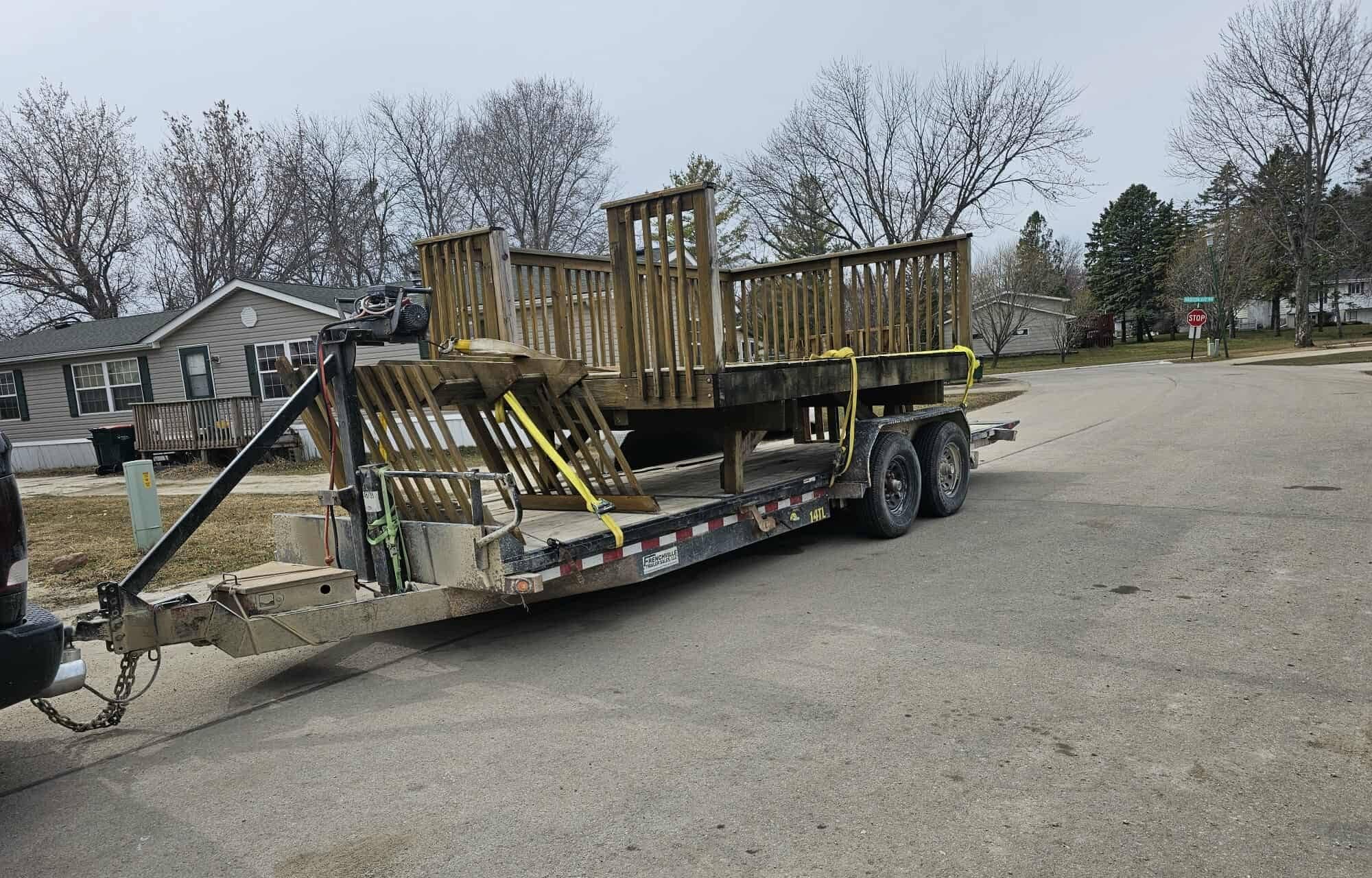 Demolished deck sections strapped on a flatbed trailer