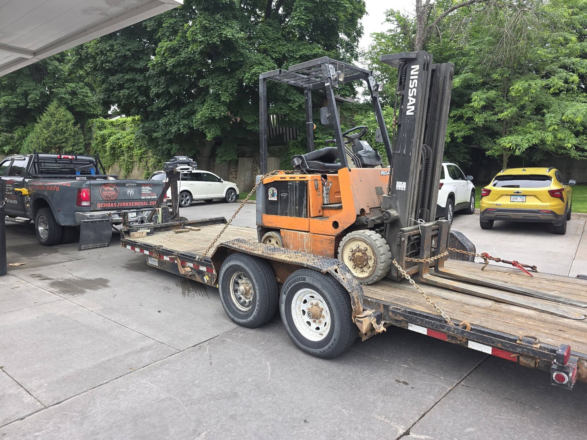 Nissan forklift chained on Ochoa's tilt trailer