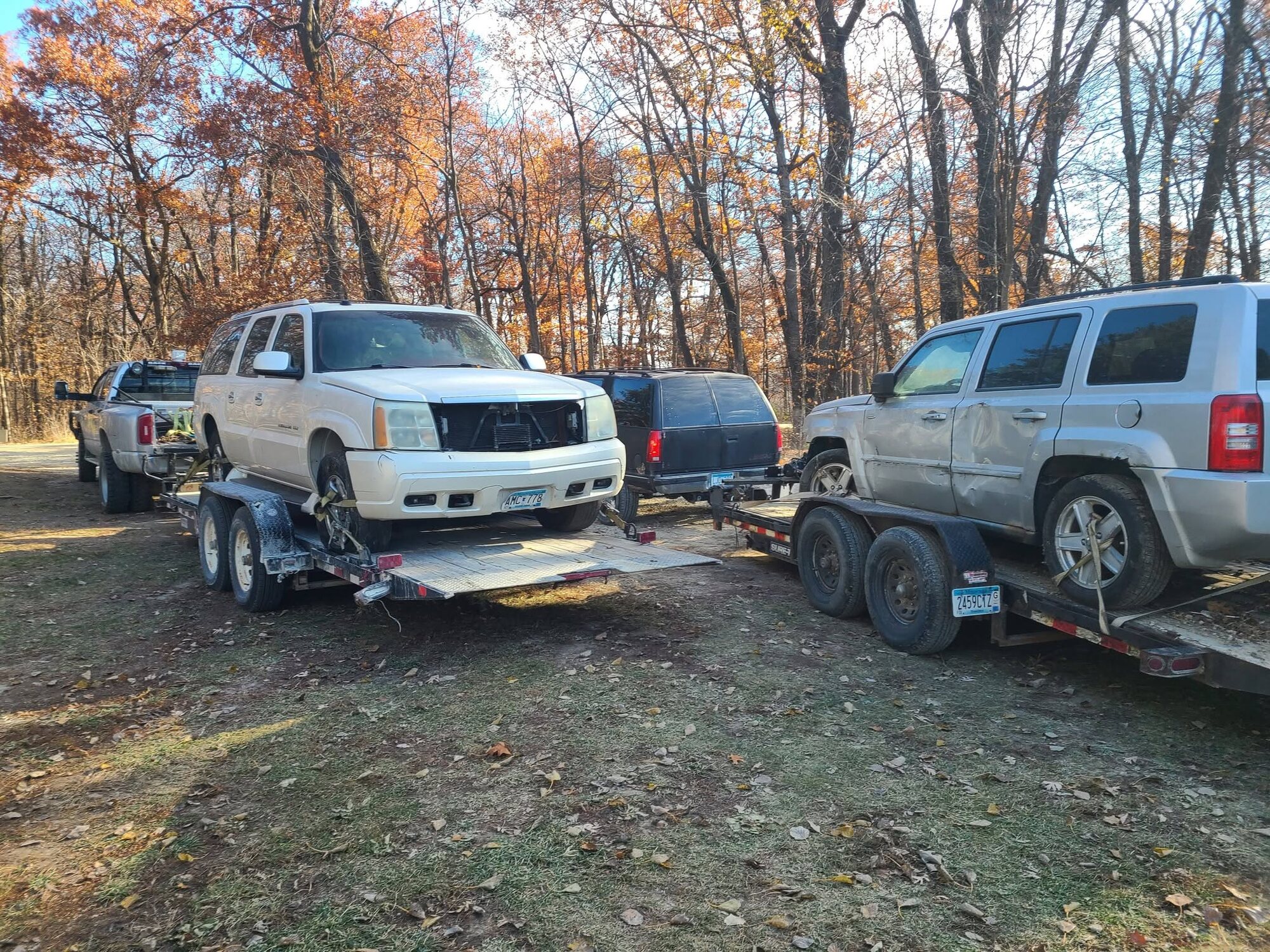 Two SUVs loaded on tilt trailers for vehicle transport